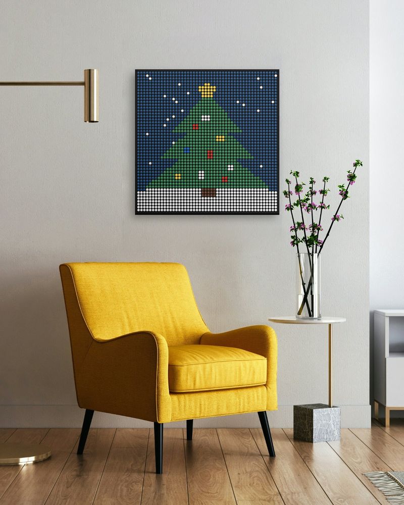 A holiday tree mosaic hanging above a yellow armchair